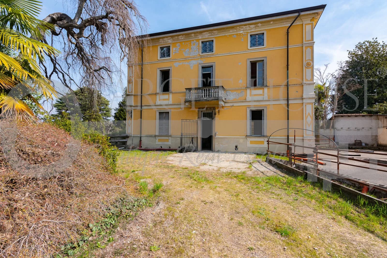 Historic villa near Como with yellow ochre facade, balcony, and overgrown 1,500 sqm garden awaiting restoration